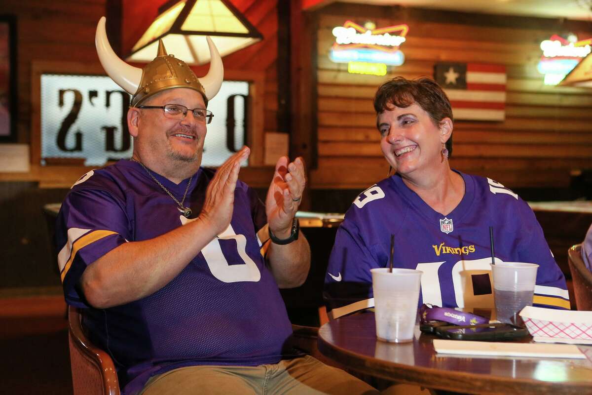 Robert Fisk, left, a diehard Vikings fan originally from Minnesota, and his wife Carrol, a newly converted fan, watch a Minnesota Vikings preseason game with other fans at Rod Dog's Saloon.