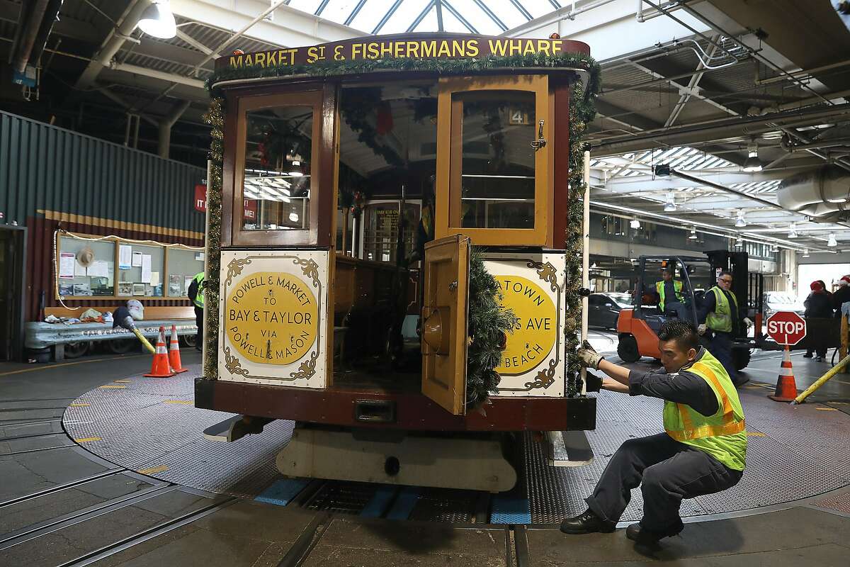 A look at cable car of grip man Val Lupiz being turned by cable car mechanic Sammy Li at the cable car barn on Tuesday, Dec. 11, 2018, in San Francisco, Calif.