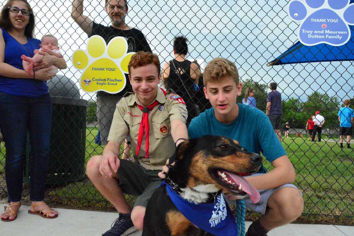 Cayden Fischer, left, with his brother Logan and rescue dog Mocha, finally got to see his Eagle Scout project become a reality with the opening of the Friendswood PetSafe Dog Park at Old City Park.