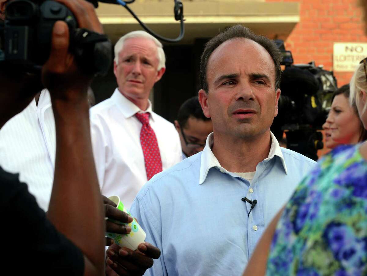 Joe Ganim, right, and Bill Finch, in background at left, attend a vigil outside the Trumbull Gardens Community Center on Trumbull Avenue in Bridgeport, Conn., on Thursday June 11, 2015. A shooting at 1 a.m. in a parking lot across the street from the center, left one man dead and seven others injured.