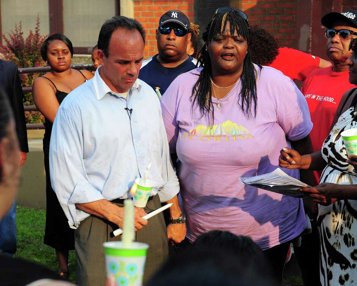 Joe Ganim, left, stands with Linda Foster, during a vigil at Trumbull Gardens Community Center in Bridgeport in 2015. Ganim criticized his predecessor’s record on public safety during his campaign four years ago.