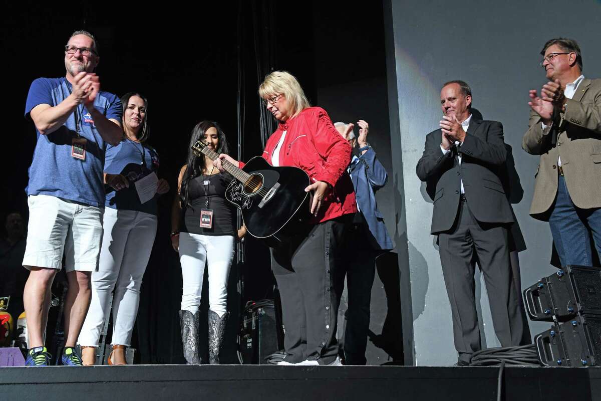 Maureen Kersten of Dickinson is given a Rascal Flatts autographed guitar in recognition of being the one millionth fan at the Smart Financial Centre on Thursday, Aug. 29.