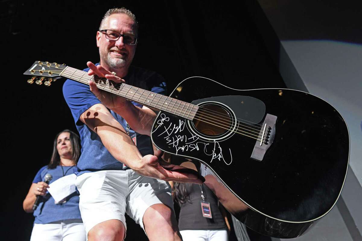 Kevin Kline of The New 93Q Country displays a Rascal Flatts autographed guitar that was given away to the one millionth fan at the Smart Financial Centre on Thursday, Aug. 29.
