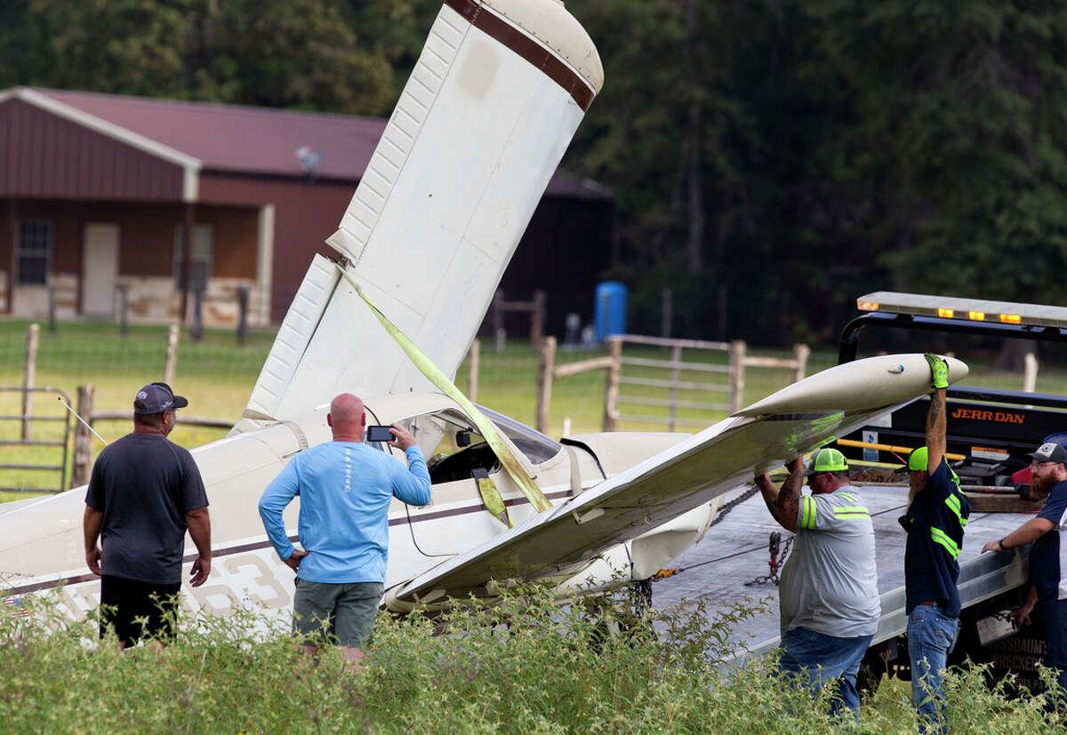 A plan is moved from a small pond after it crashed, injuring two people with minor injuries along Seven Coves Road near Farrell Road, Saturday, Aug. 31, 2019, in Willis. The plane was headed for Conroe-North Houston Regional Airport when air traffic controllers dispatched firefighters for a report of an aircraft emergency.