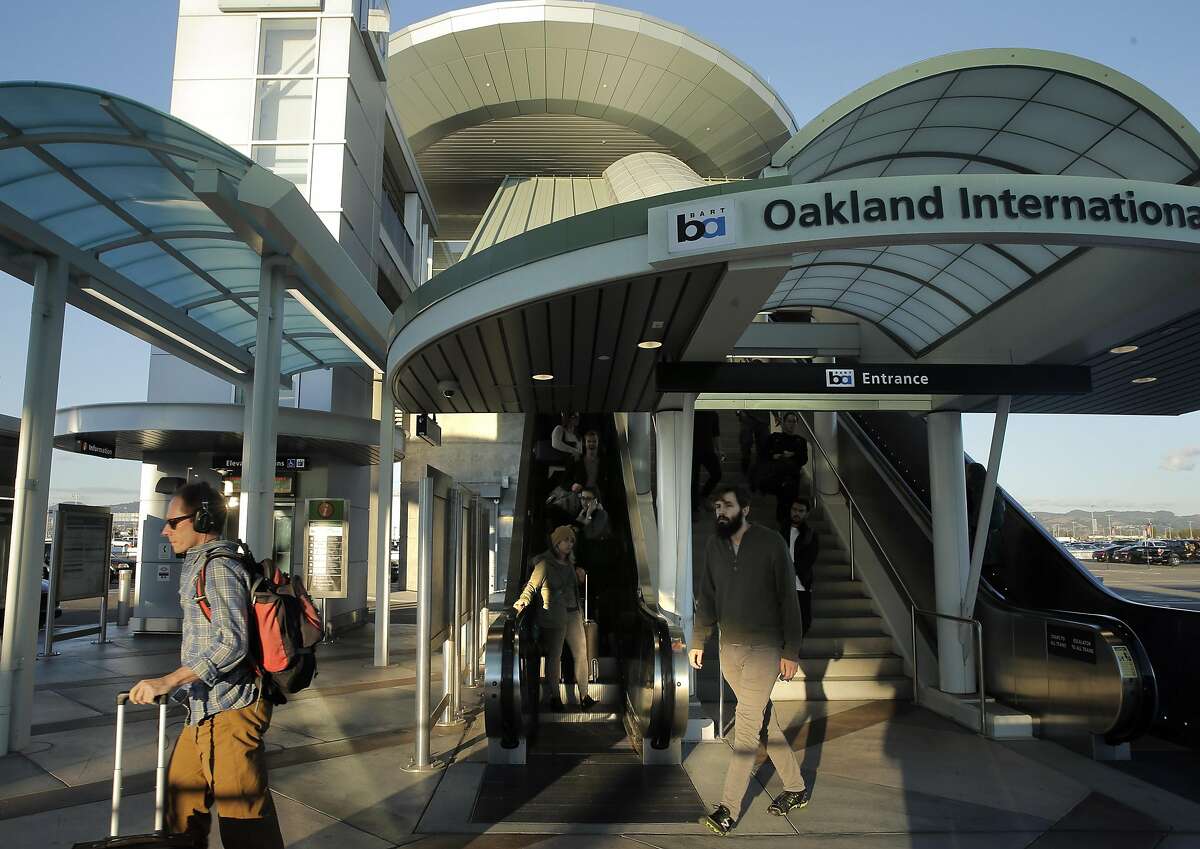 Airport passengers arrive at Oakland International Airport from the Oakland Airport Connector from the Coliseum BART Station in Oakland, Calif., on Wednesday, November 25, 2015.