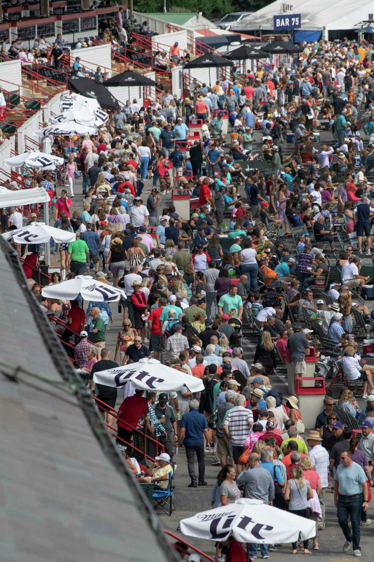 A huge line forms near the umbrellas at the Saratoga Race Course on sweatshirt giveaway day Sunday Sept. 1, 2019 in Saratoga Springs, N.Y. Photo Special to the Times Union by Skip Dickstein