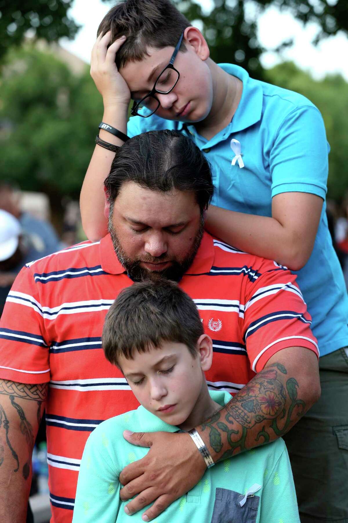 Michael Pules prays with his sons, Luke, 13, top, and Liam, 11, during a vigil at the University of Texas of the Permian Basin in Odessa, Texas on Sunday, Sept. 1, 2019. The vigil was for the victims of Saturday's mass shooting. Seth Aaron Ator, 36, of Odessa, is suspected of killing seven people an injuring 19 in a shooting spree on Saturday.