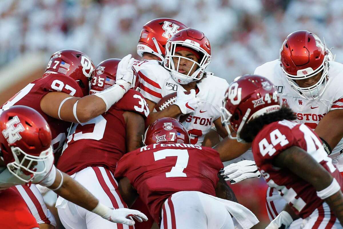 UH running back Kyle Porter, center, is swallowed up by a host of Oklahoma defenders in the second quarter of Sunday’s game.