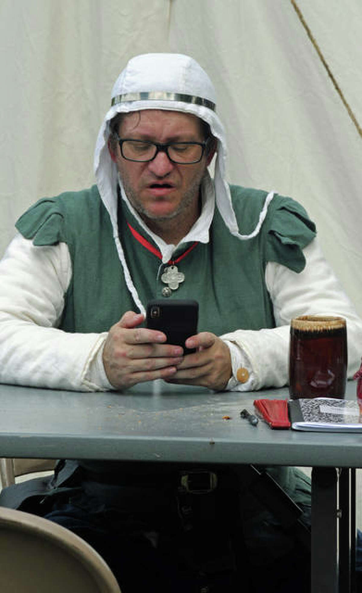 A Renaissance re-enactor checks his modern day messages during a break in the Bardic Congress and Cooks Collegium. The event ran Friday through Monday at Wood River’s Camp Dubois.