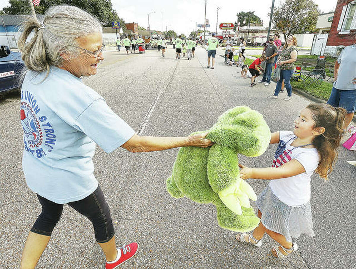 Lucia Barragan, 6, of Granite City, receives a large stuffed frog from members of Machinists District 837 in St. Louis who brought a pickup truck full of stuffed animals to hand out to children at this year’s parade.
