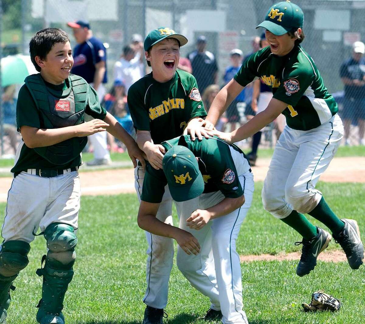 SPECTRUM/New Milford players, back row, left to right, Robert Mosso, Brendan Profita and Tim Gesualdi, celebrate with Tyler Hansen, who pitched the last three innings for the New Milford Youth Baseball/Softball 11-year-olds in the state championship game vs. Danbury. New Milford defeated Danbury, 10-6, to win the Cal Ripken 11-year-old state tournament championship July 31, 2010 at Rogers Park.