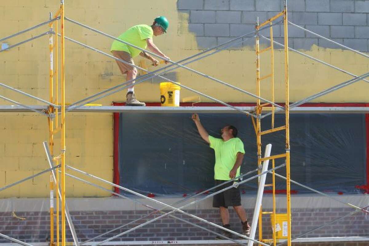 Construction workers hurry to finish the outside of Mecosta Elementary School. The two additional classrooms will not be ready for inspection by the time school starts. (Pioneer photo/ Catherine Sweeney)