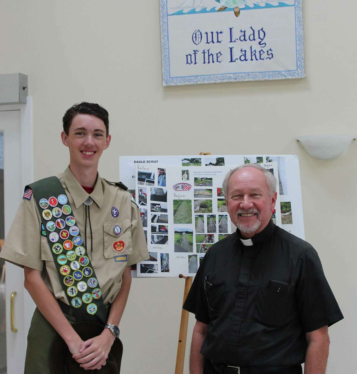 Connor Woods is shown with the Rev. Gerald H. Dziedzic, pastor of Our Lady of the Lakes, standing in the vestibule of the church. Connor created the “Thank you” poster for the church as part of his Eagle Scout project.