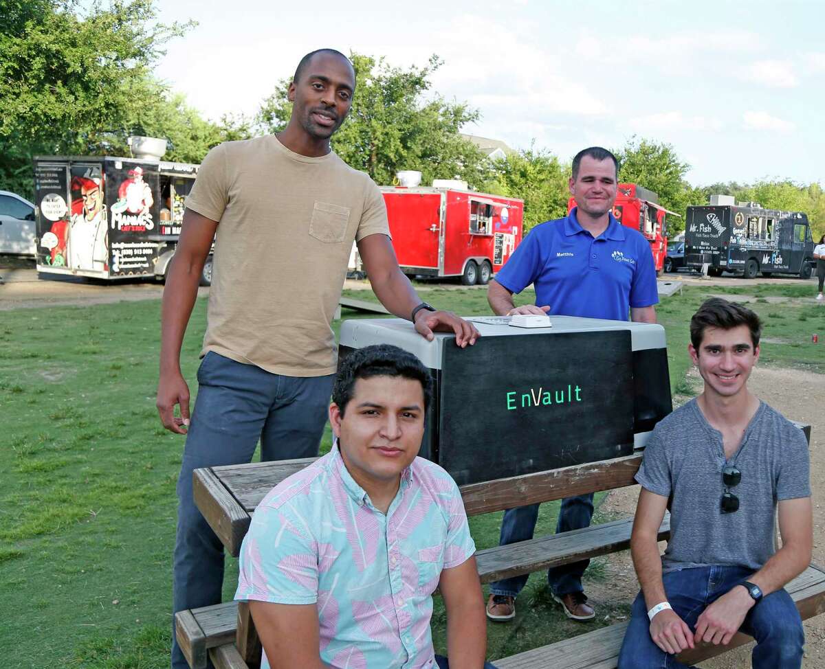 Jose Flores, CEO, sitting L, Nelson Falcon, CTO, front R, Robert Brothers, CSE, back L, and Matthis Herrera, back R, pose with shell of their green alternative to vehicle mounted generators which they called Vault O(Beta model pose with shell of it in front of mobile business that they hope will use. The entrepreneurs who own Envault, a start-up working on a battery power system for mobile businesses, such as pet groomers and food trucks. Photos taken on Sunday, July 28, 2019.