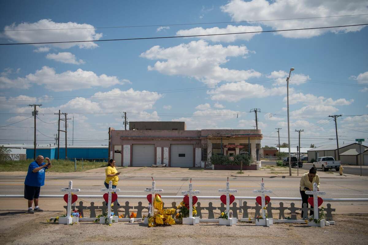 People pay their respects at a makeshift memorial created in memory of the victims killed in a recent mass shooting in Odessa, Texas, Sept. 3, 2019. Attacked across two cities, the victims were linked by fate and an enraged gunman. They were white and Hispanic, mothers and police officers, letter carriers and retirees. (Loren Elliott/The New York Times)