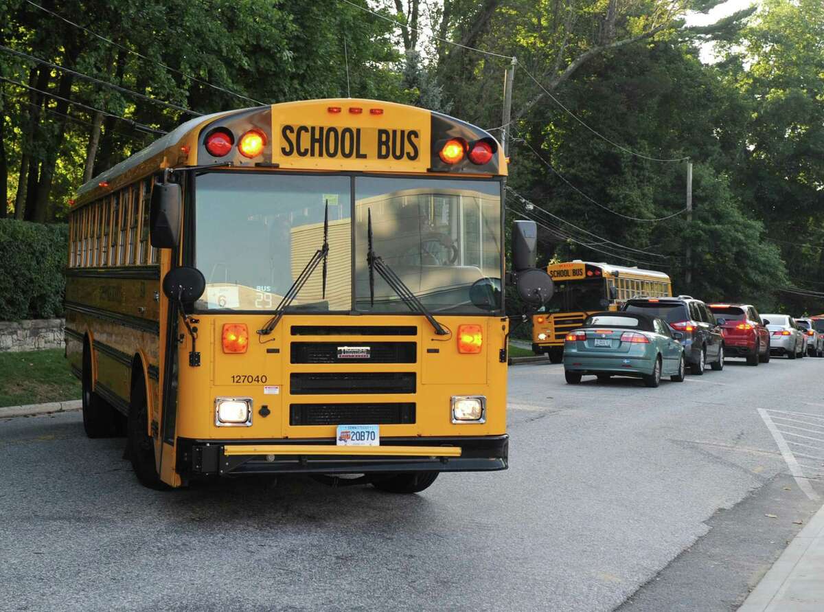 A school bus turns into Greenwich High as a long line of cars wait to leave on the first day of the 2017-2018 school year at Greenwich High School in Greenwich, Conn. Thursday, Aug. 31, 2017.