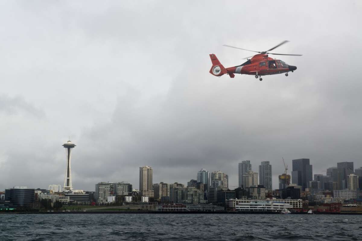 A Coast Guard Air Station Port Angeles MH-65 rescue helicopter flies over Elliott Bay.