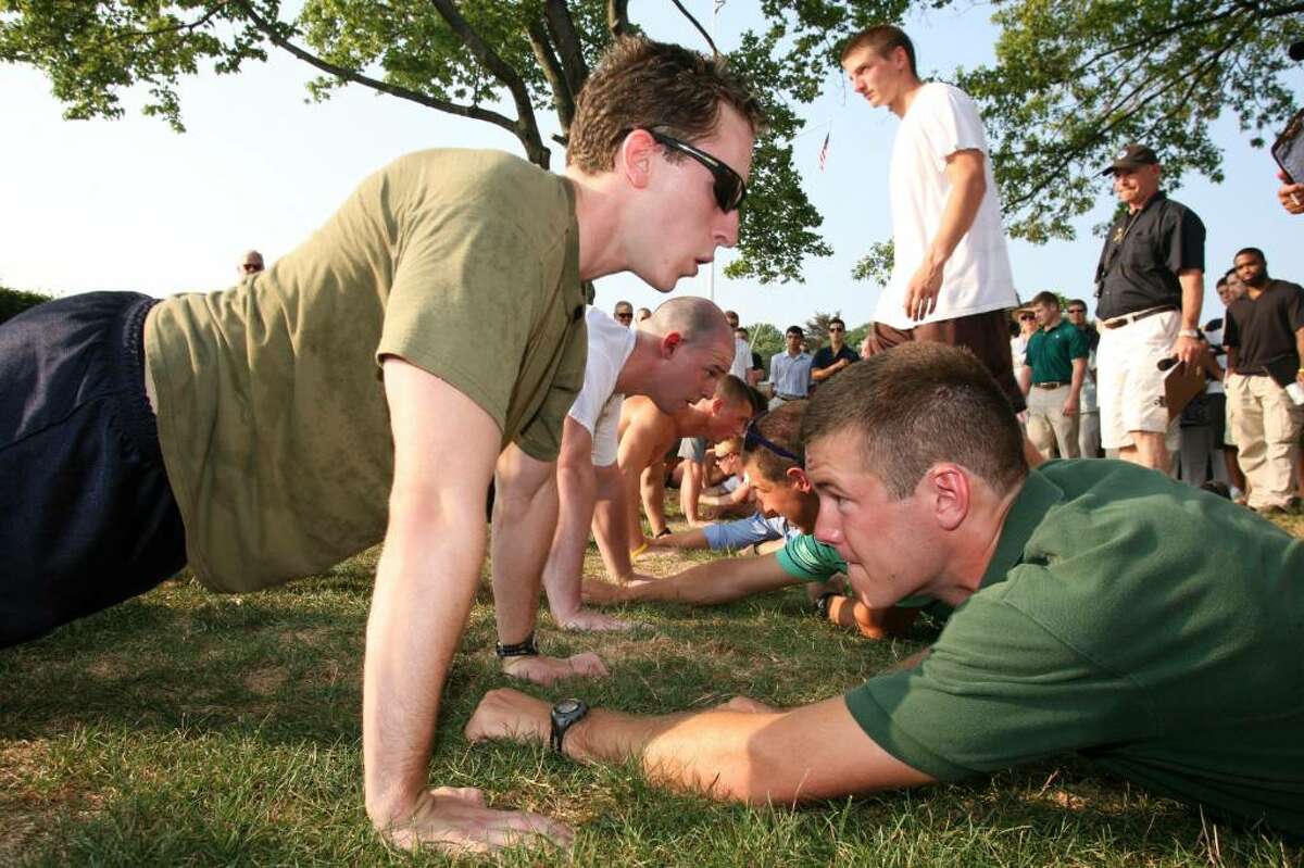 Navy SEALs candidate Dan Weeks, left, attempts to do as many push-ups as he can in two minutes during Wednesday evening's Physical Screening Test at the Riverside Yacht Club.