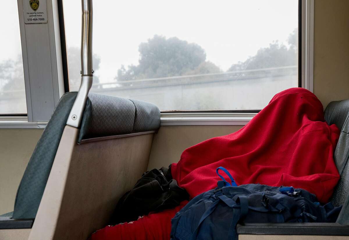 A person sleeps underneath a blanket on a Warm Springs bound BART train in Oakland, Calif. Tuesday, September 3, 2019.