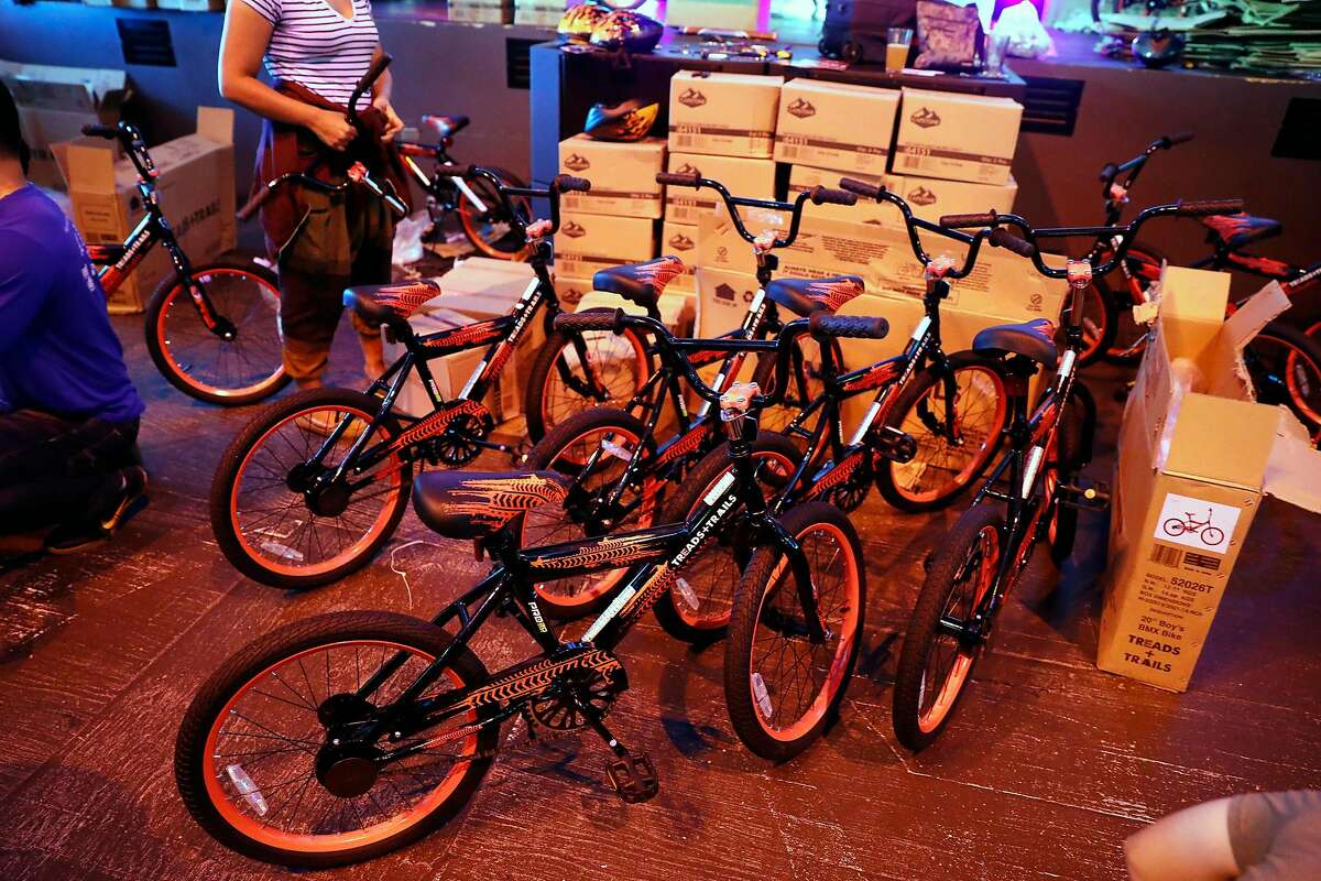 Volunteers help build bikes for students at McCoppin Elementary School at Emporium Arcade Bar in San Francisco, Calif., on Tuesday, September 3, 2019.