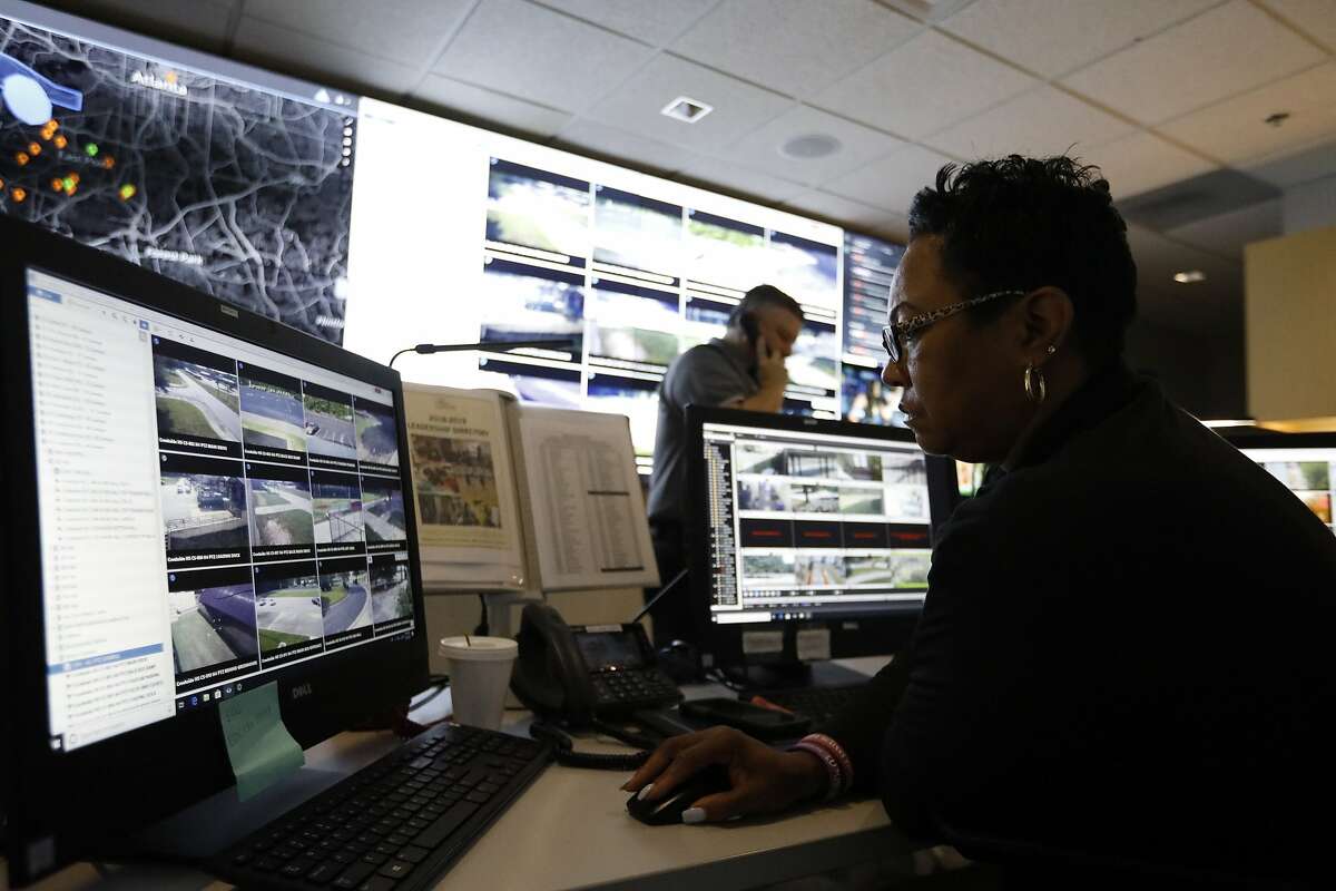 In this July 30, 2019, photo, Sandra Swint, right, campus security associate for Fulton County School District and Paul Hildreth, background, the district’s emergency operations coordinator, work in the emergency operations center at the Fulton County Schools Administration Center in Atlanta. Artificial Intelligence is transforming surveillance cameras from passive sentries into active observers that can immediately spot a gunman, alert retailers when someone is shoplifting and help police quickly find suspects. Schools, such as the Fulton County School District, are among the most enthusiastic adopters of the technology. (AP Photo/Cody Jackson)