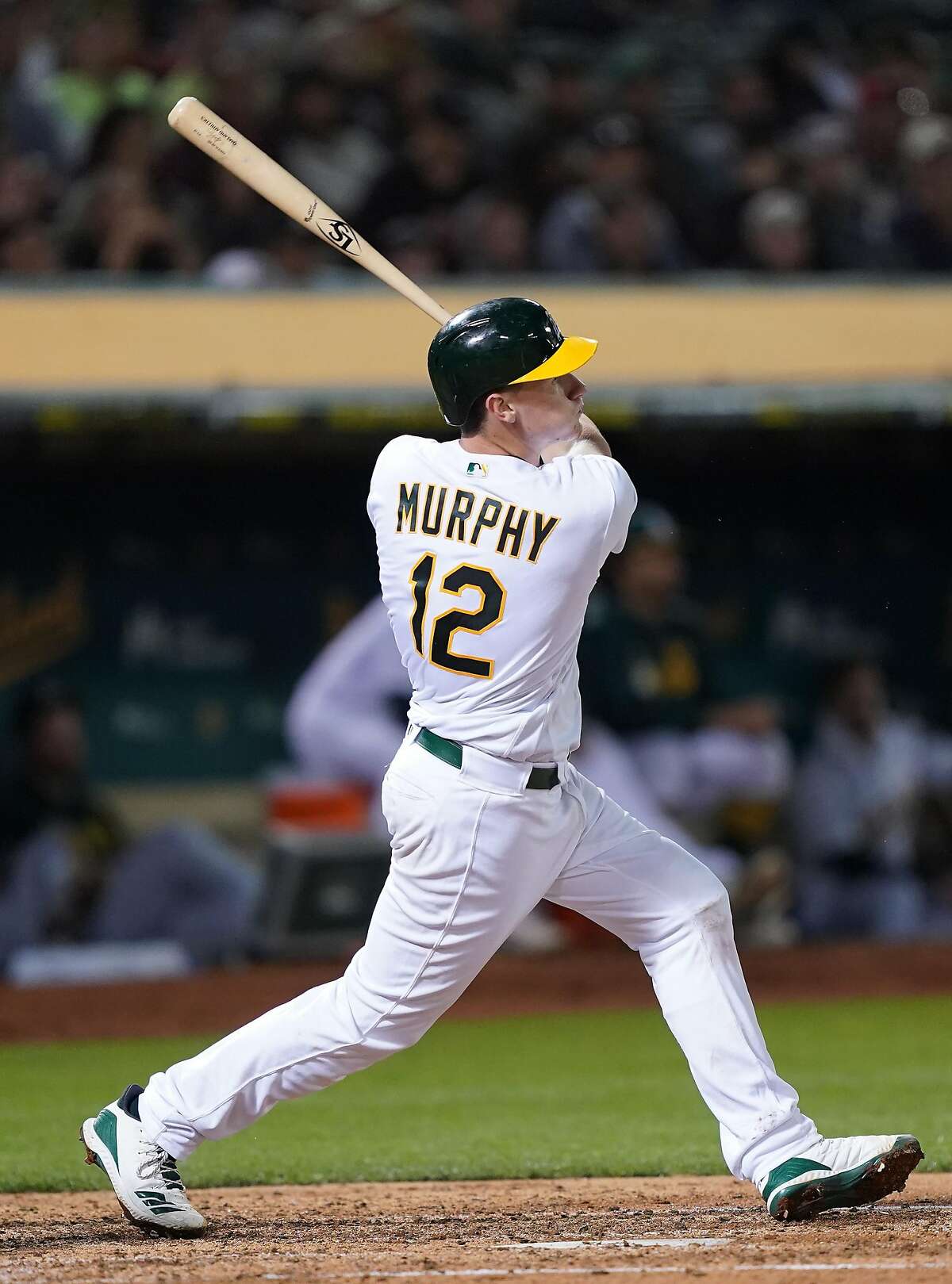 OAKLAND, CALIFORNIA - SEPTEMBER 04: Sean Murphy #12 of the Oakland Athletics during his Major League debut hits a solo home run against the Los Angeles Angels of Anaheim in the bottom of the fifth inning at Ring Central Coliseum on September 04, 2019 in Oakland, California. The home run was is first Major League hit. (Photo by Thearon W. Henderson/Getty Images)