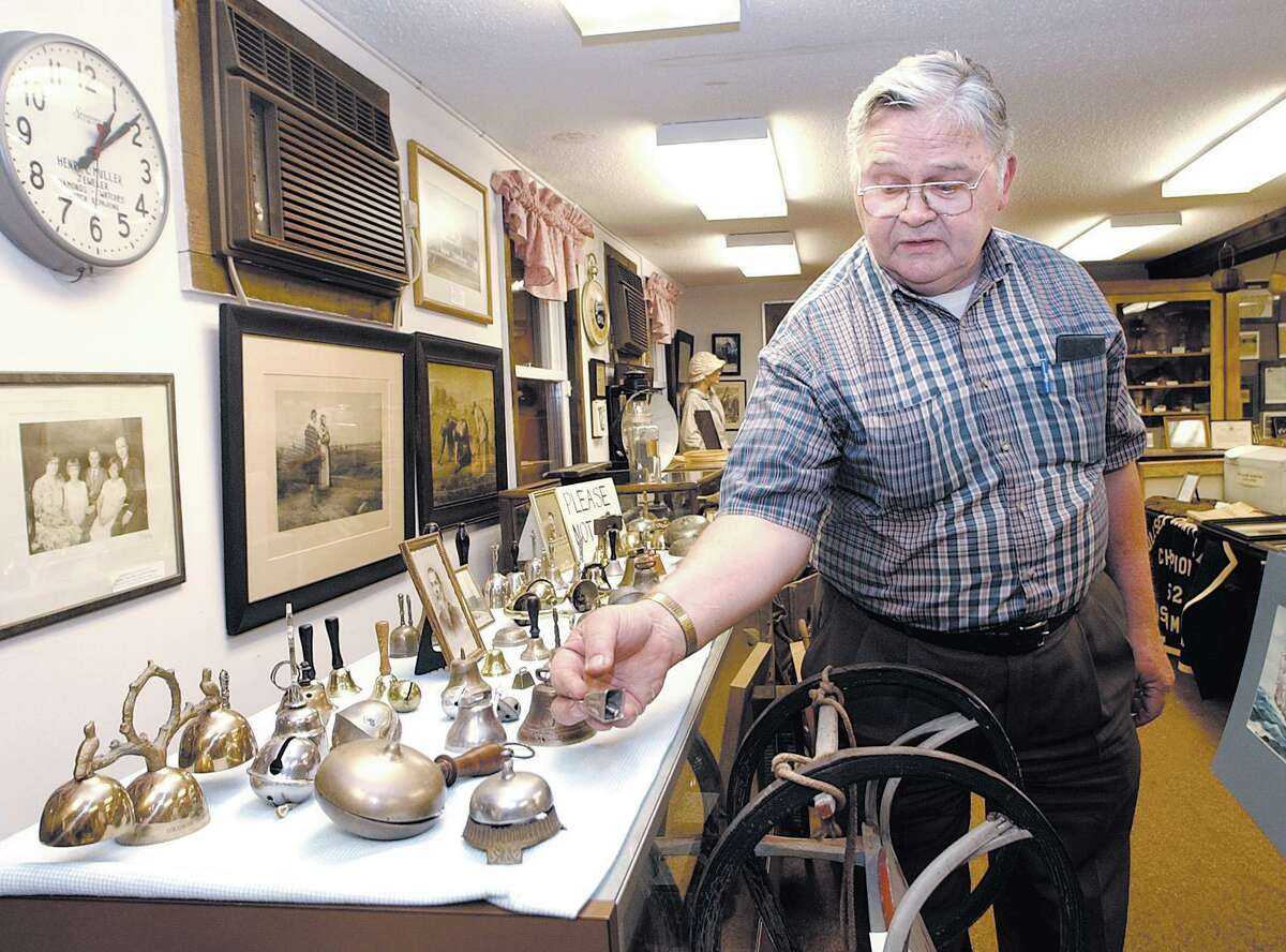 Walter Olson, past president of the Chatham Historical Society and former employee at Bevin Bell Co., shows the East Hampton museum’s bell collection in this archive photograph.