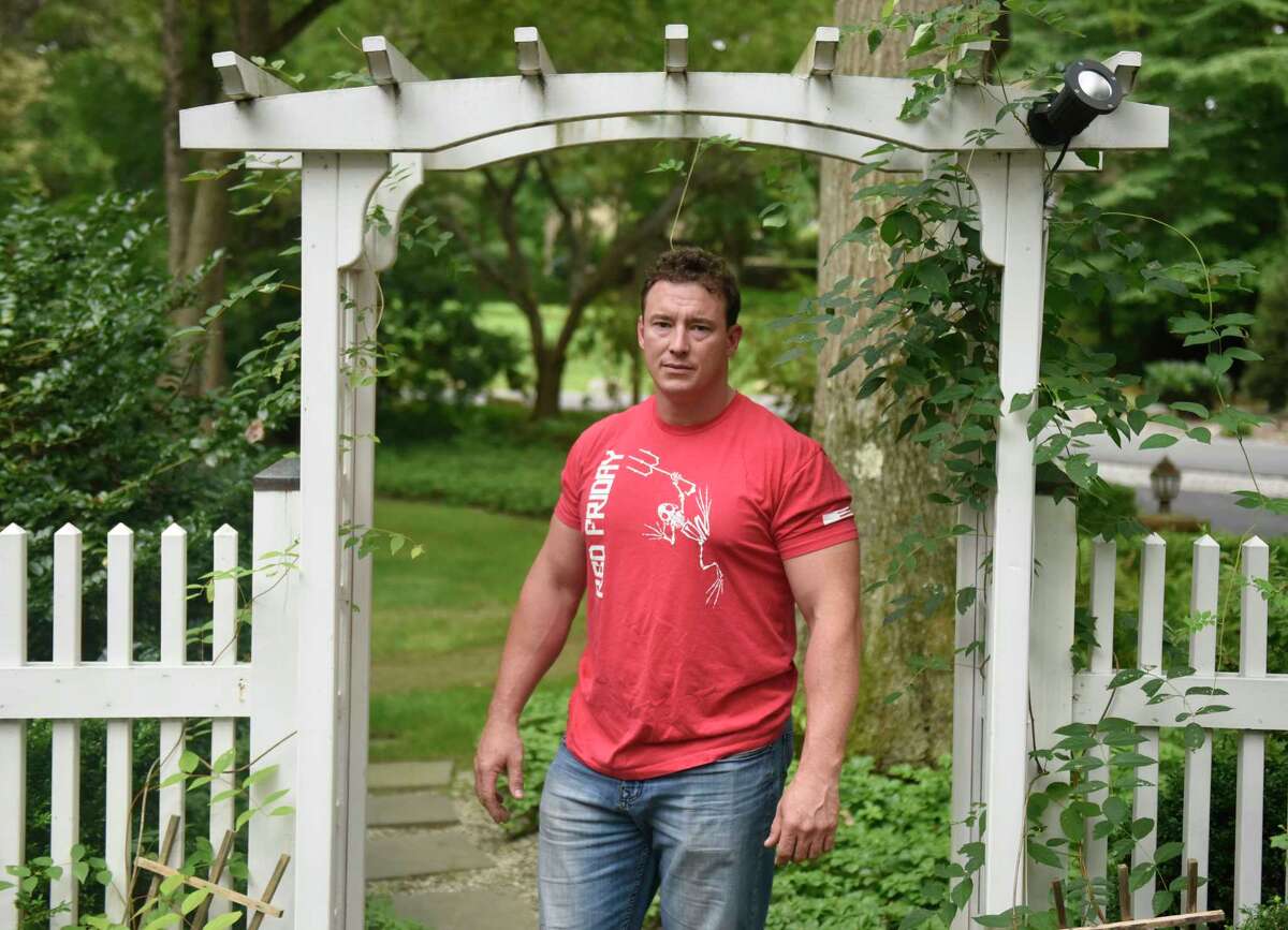 Former Navy SEAL and Trump political operative Carl Higbie poses outside his home in the Cos Cob section of Greenwich, Conn. Thursday, Sept. 5, 2019. Higbie's car was recently vandalized with a swastika and he believes it is because of his Trump bumper sticker.