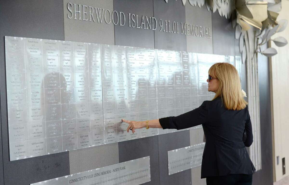 Former flight attendant Sari Weatherwax, who lost co-workers on 9/11, touches the names at the memorial.
