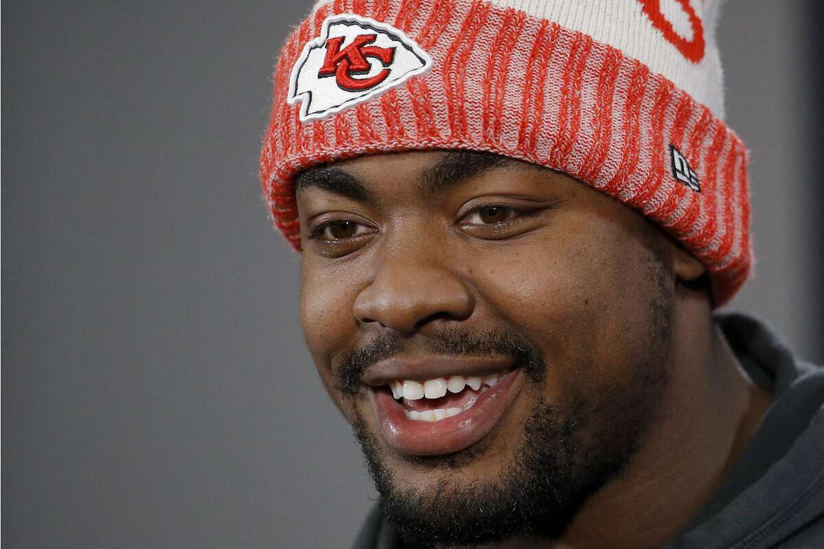 FILE - In this Jan. 18, 2019, file photo, Kansas City Chiefs defensive end Chris Jones talks to the media after a workout in Kansas City, Mo. Chris Jones tried to keep a straight face, answer the reporter's question in a serious manner. But standing behind him on a chair was defensive tackle Derrick Nnadi, all 330 pounds of him, flexing and jiggling and gyrating. The Chiefs defensive tackle finally cracked. This is life in the Kansas City locker room.(AP Photo/Charlie Riedel, File)