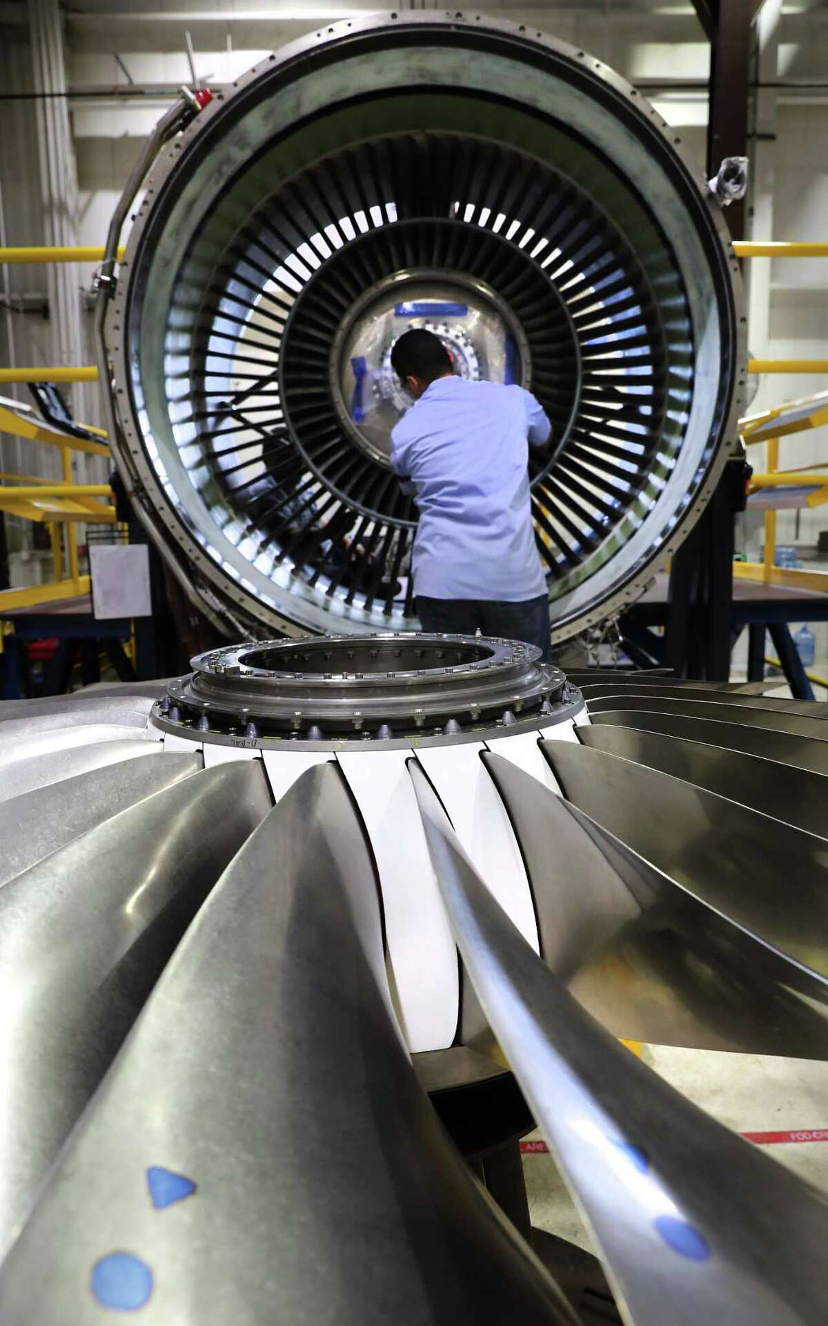 An worker at StandardAero disassembles a RB211 jet engine from a Boeing 757. The company, which is located at Port San Antonio, manufactures and refurbishes airline engines.