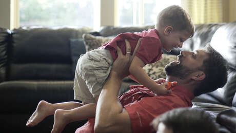 Tim Timmerman plays with his youngest son, Tristan, in their Cinco Ranch, Texas home.