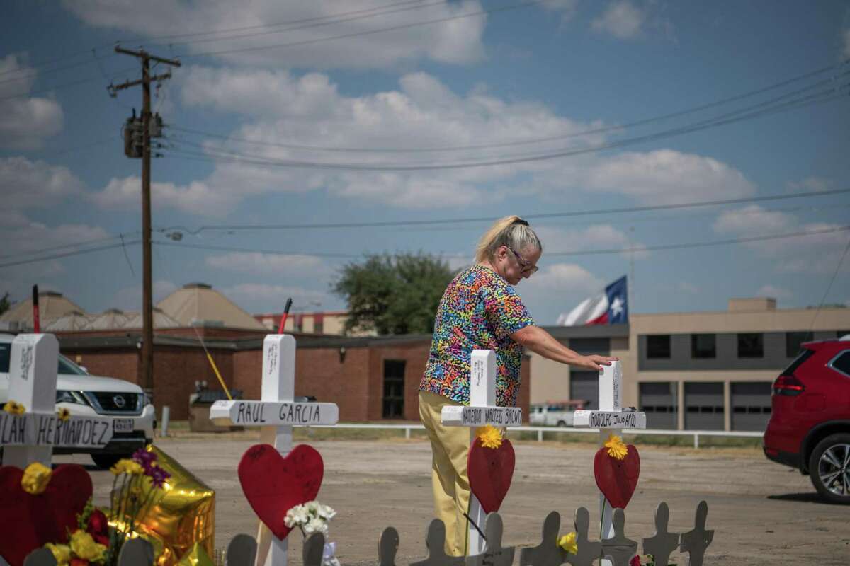 An Odessa resident pays her respects at a makeshift memorial created in memory of the victims killed in a recent mass shooting in Odessa, Texas, Sept. 3, 2019.