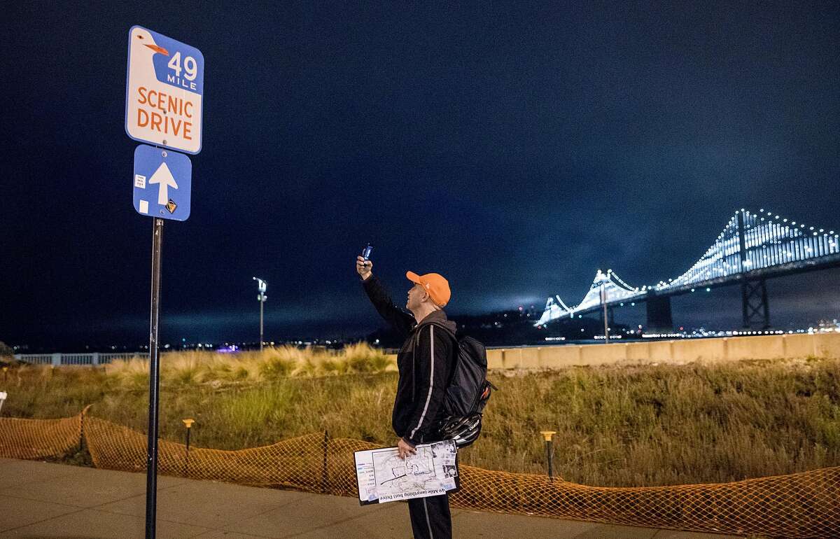 San Francisco Chronicle reporter Peter Hartlaub takes a picture of the 49-Mile Scenic Drive marker along the Embarcadero in San Francisco, Calif. Wednesday, September 4, 2019 as he and fellow reporter Heather Knight attempt to traverse San Francisco�s 49-mile Scenic Drive without using a car.
