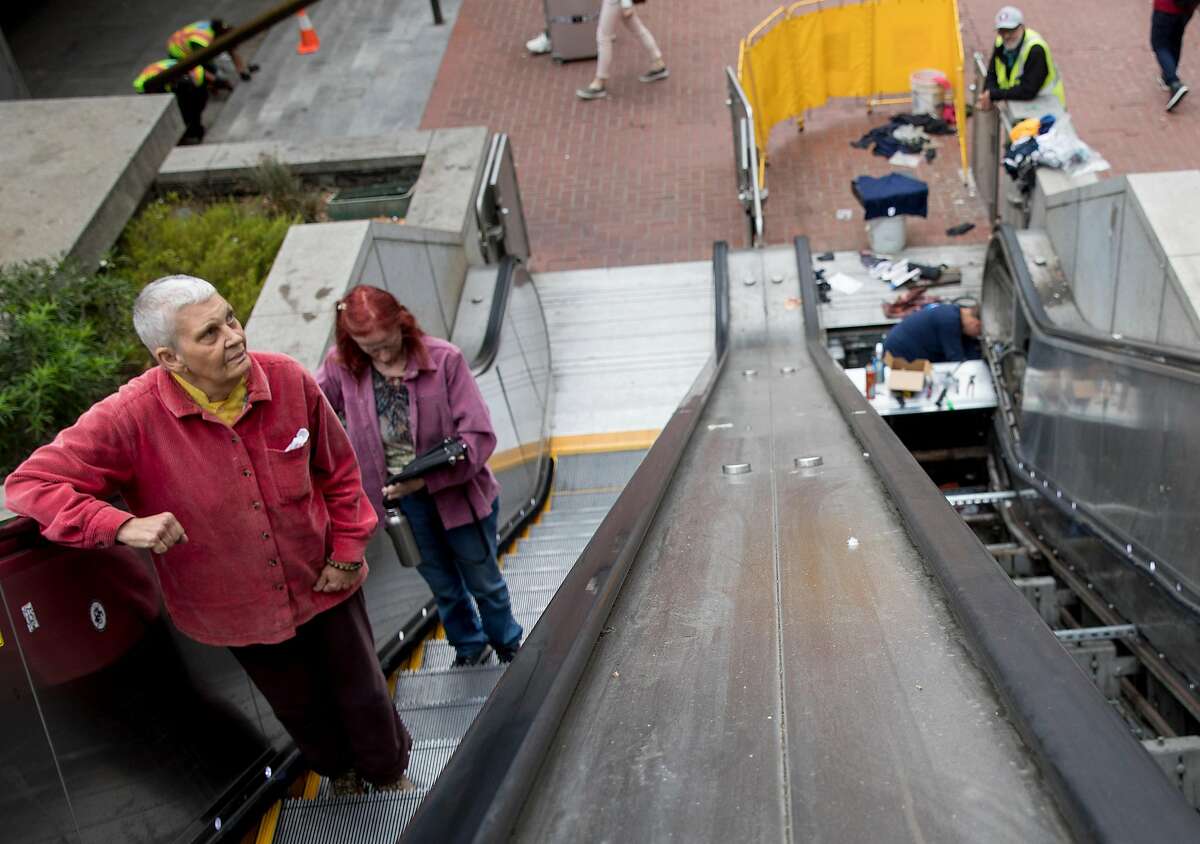Riders make their way up an escalator as another is being repaired at the Powell Street BART Station in San Francisco, Calif. Friday, September 6, 2019.
