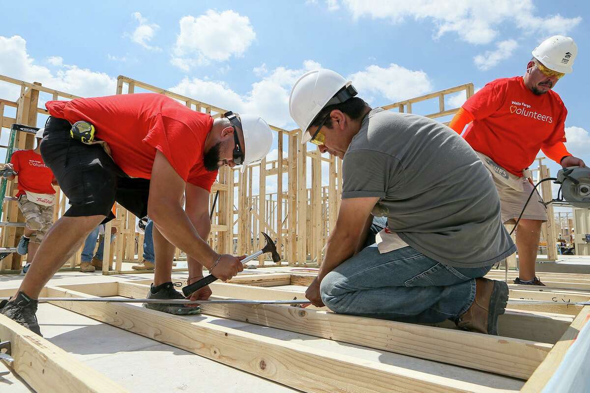 Habitat for Humanity volunteers Martin Gatica, from left, Robert Chavarria and Arnulfo Aguilar, from Wells Fargo, attach a metal brace to a wall frame before raising it while building a new home in the Lenwood Heights subdivision on Friday, Sept. 6, 2019. The nonprofit is building 10 homes expected to be ready before the holidays.