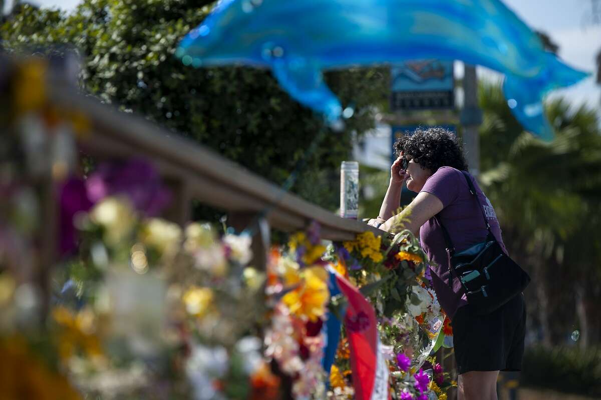 A woman gets emotional after placing flowers at a memorial for the victims of the Conception in the Santa Barbara Harbor on Wednesday, Sept. 4, 2019 in Santa Barbara, Calif. A fire raged through the boat leaving 34 people dead. (AP Photo/Christian Monterrosa)