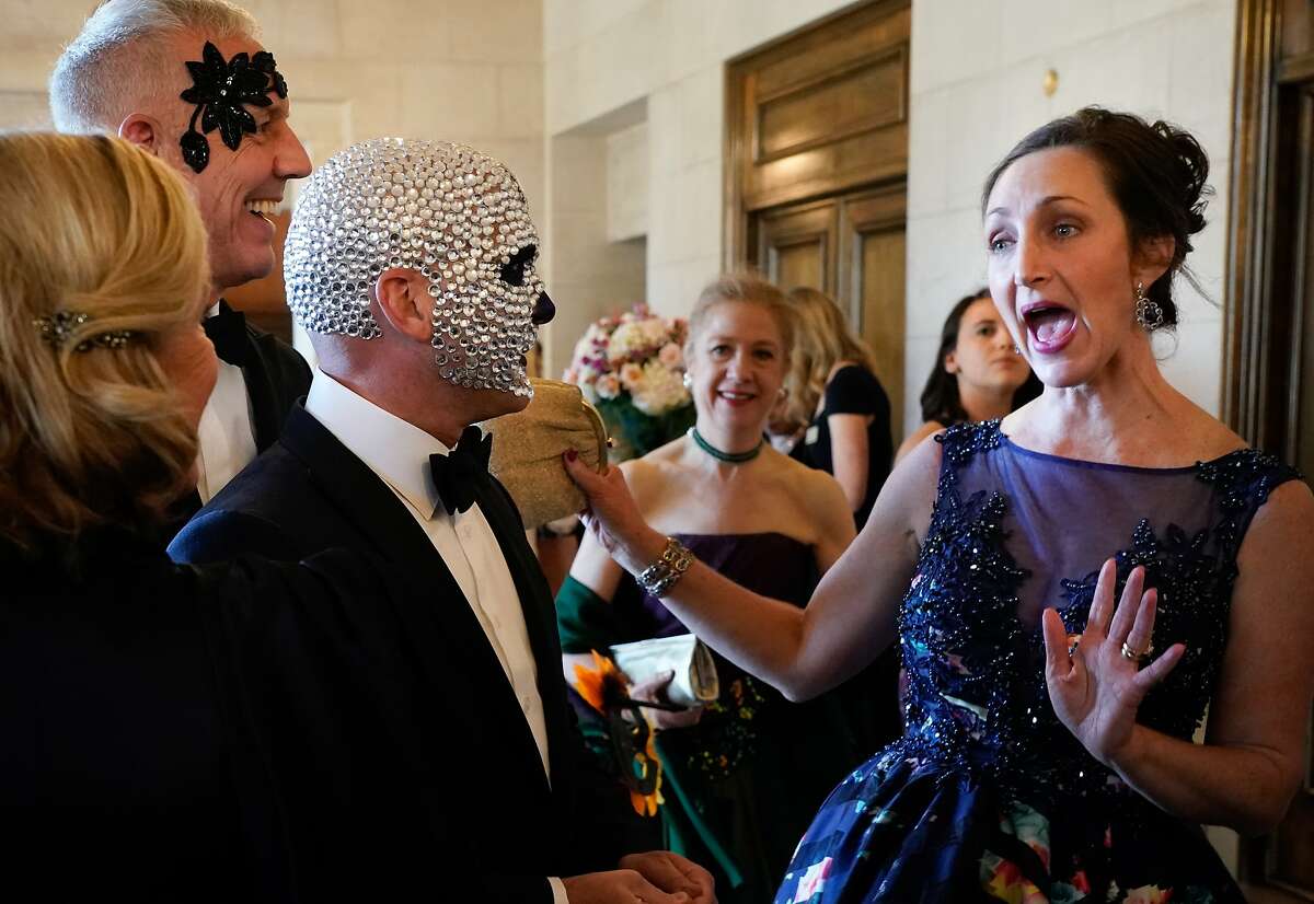 Ronnie Genotti (middle) and David Oldroyd (left) are greeted by Alison Morr Gemperle at the start of the 2019 Opera Ball on Friday in San Francisco.