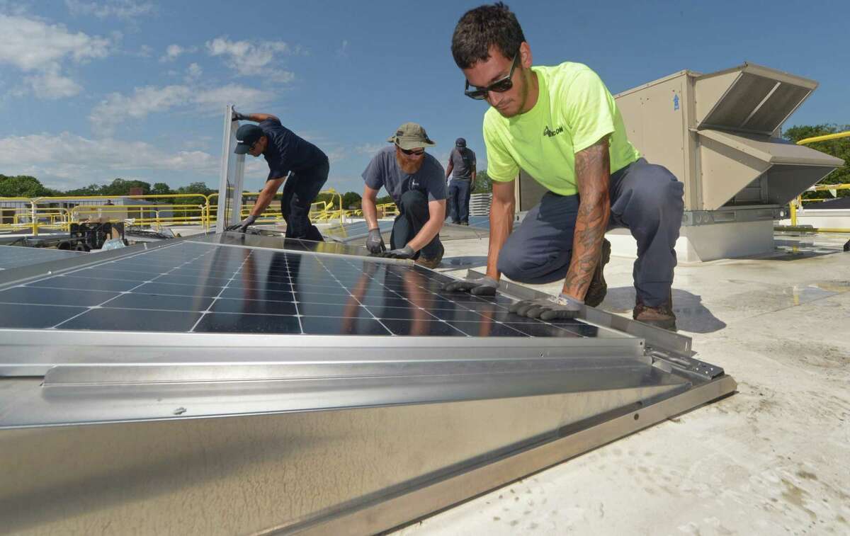Encon employees install solar panels on the roof of the Paul Miller Nissan dealership in Fairfield last year.