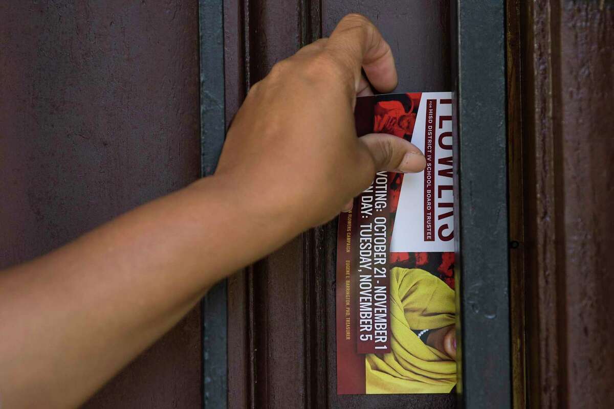 Dr. Reagan Flowers places a campaign card in a mailbox as she walks through a neighborhood campaigning for a seat on the Houston ISD school board on Saturday, Sept. 7, 2019, in Houston. Flowers is one of four candidates running to replace outgoing District IV Trustee Jolanda Jones