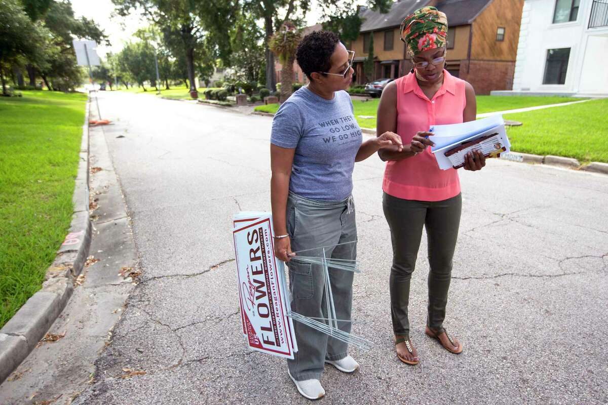 Dr. Reagan Flowers, left, and volunteer L.J. Garfield walk through a neighborhood as she campaigns for a seat on the Houston ISD school board on Saturday, Sept. 7, 2019, in Houston. Flowers is one of four candidates running to replace outgoing District IV Trustee Jolanda Jones