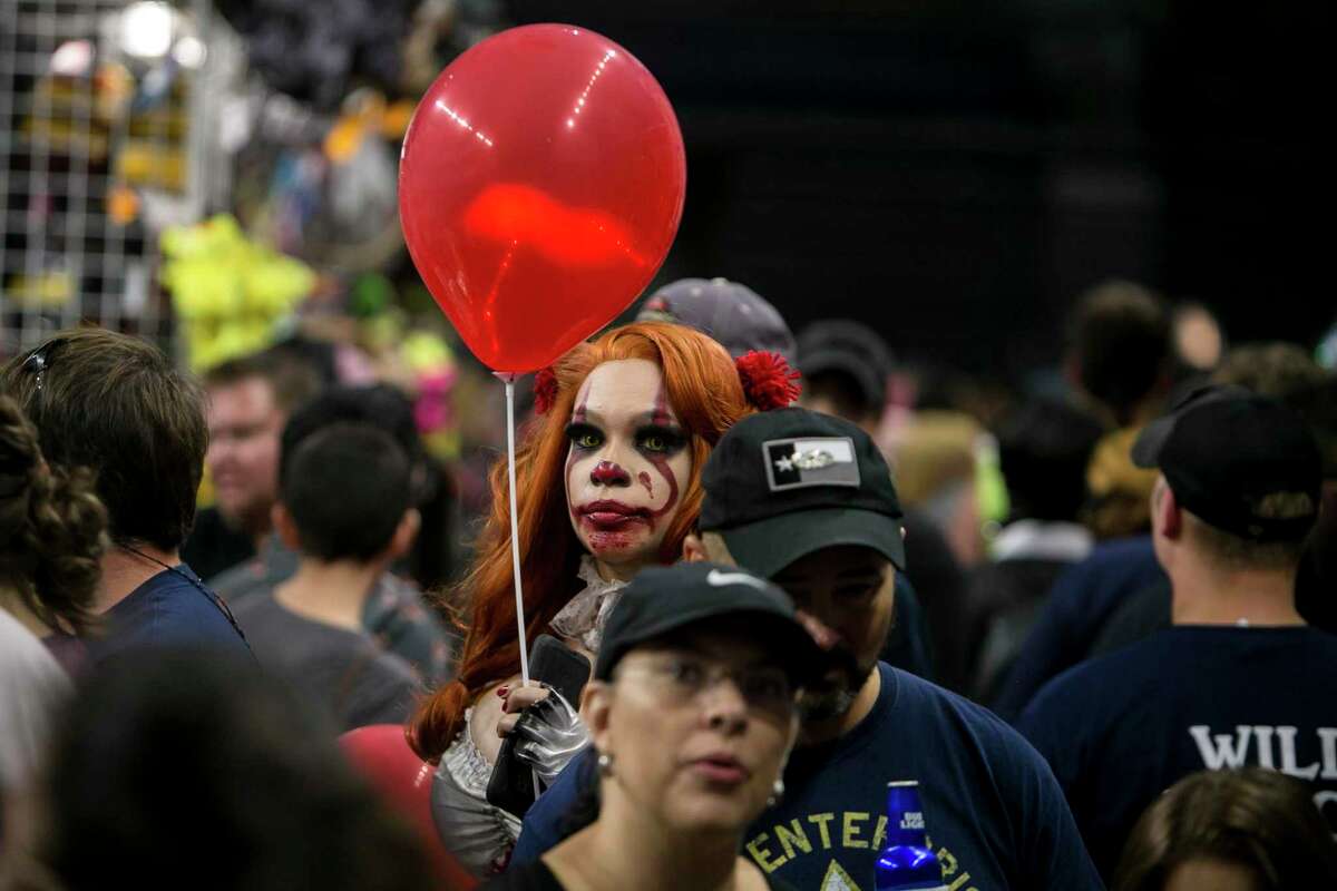 A woman cosplaying Pennywise makes her way through the crowds at Alamo City Comic Con at the Alamodome in October 2018.