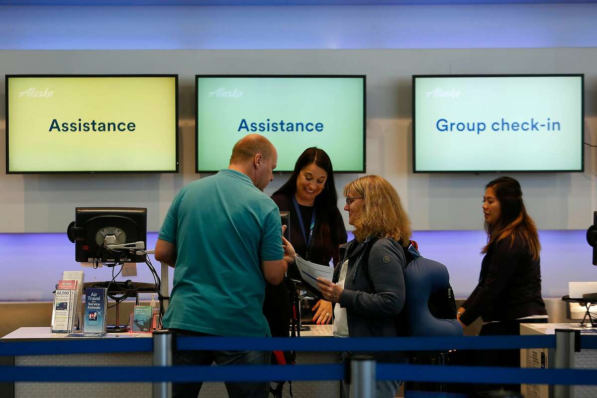 Andre Schultz (l to r) and Bettina Schutz, both of Germany, are helped at a ticketing counter at San Francisco International Airport on Monday, September 9, 2019 at SFO in San Francisco, CA.
