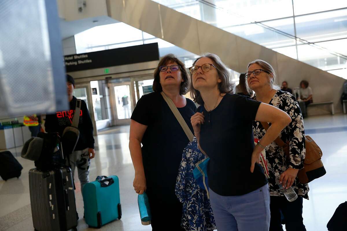 Betsy Curlin of Illinois (l to r) , Karen Kramer of Massachusettes and Shirley Kramer of Illinois study a departure and arrivals board at San Francisco International Airport on Monday, September 9, 2019 at SFO in San Francisco, CA. Curlin and Shirley Kramer said their flight times had been bounced around as it had been moved up and then back.