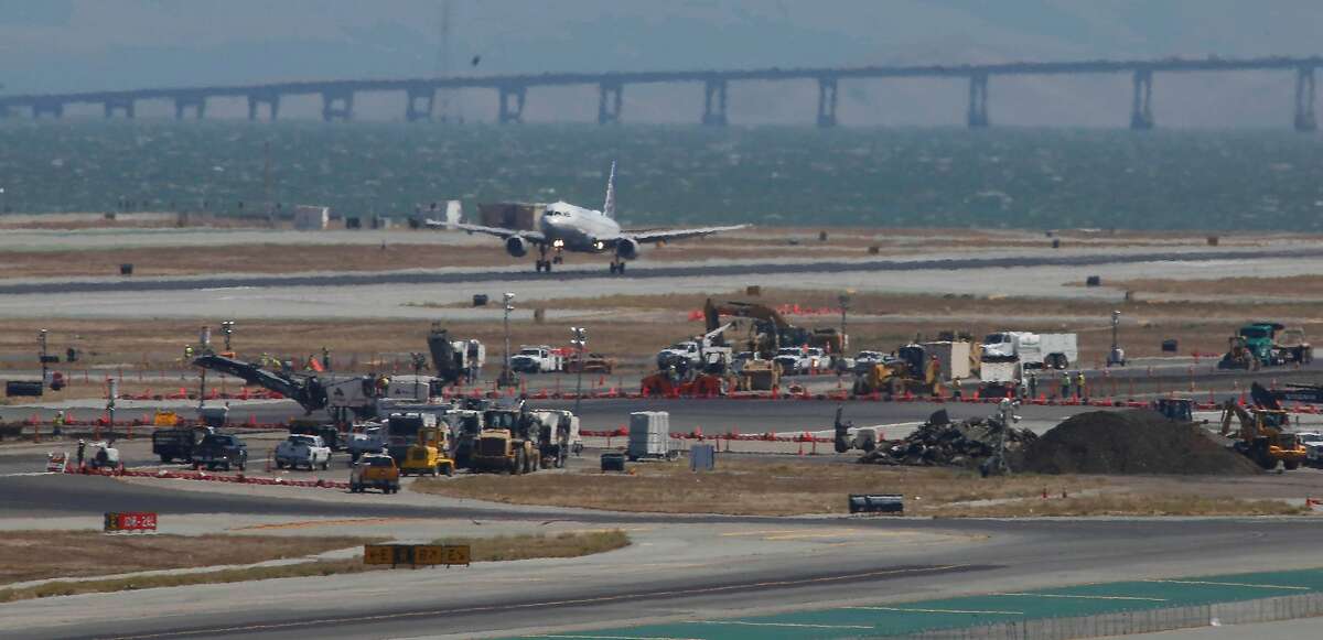 An airplane is seen landing next to construction equipment on a runway at San Francisco International Airport on Monday, September 9, 2019 at SFO in San Francisco, CA.