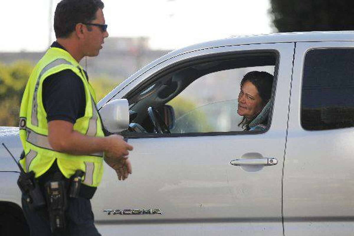 A woman reacts after SFMTA officer only identified for safety reasons as badge number 57, tells her not to go into the intersection at 2nd and Bryant Streets as part of San Francisco Municipal Transportation Agency's (SFMTA) testing of "Don't Block the Box" enforcement program at two SOMA intersections Sept. 11, 2014 in San Francisco, Calif.