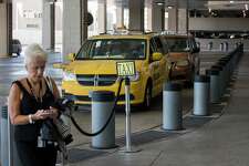 Taxi drivers wait for fares outside George Bush Intercontinental Airport on Friday, Sept. 6, 2019, in Houston. Houston taxi drivers will face lower fees and fewer regulations under a plan approved by City Council. The new rules come as taxi companies struggle to stay financially afloat amid increased competition from ride-sharing companies such as Lyft and Uber. Under the plan, the city will lower taxi permit fees from $580 to $450, and create a three-time lottery system through which almost 900 new permits will be issued by 2020.