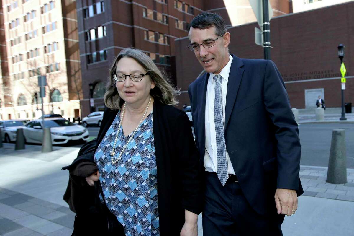 Michael Center, right, former men’s tennis coach at the University of Texas at Austin, departs federal court with an unidentified woman, Wednesday, April 24, 2019, in Boston, after he plead guilty to charges in a nationwide college admissions bribery scandal.