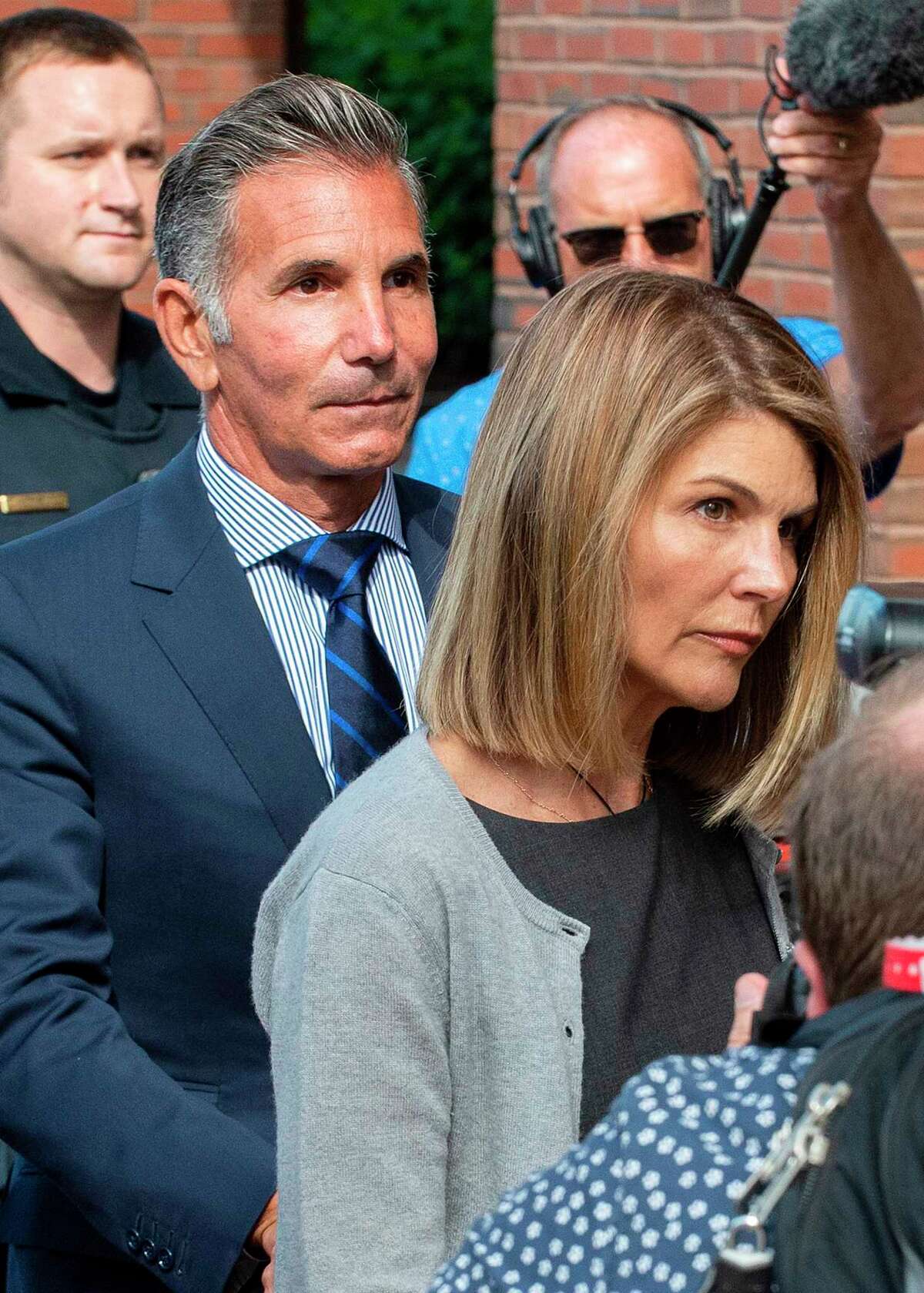 Actress Lori Loughlin, right, and husband Mossimo Giannulli exit the Boston Federal Court house after a pre-trial hearing with Magistrate Judge Kelley at the John Joseph Moakley U.S. Courthouse in Boston on Aug. 27, 2019. Loughlin and Giannulli are charged with conspiracy to commit mail and wire fraud and conspiracy to commit money laundering in the college admissions scandal.