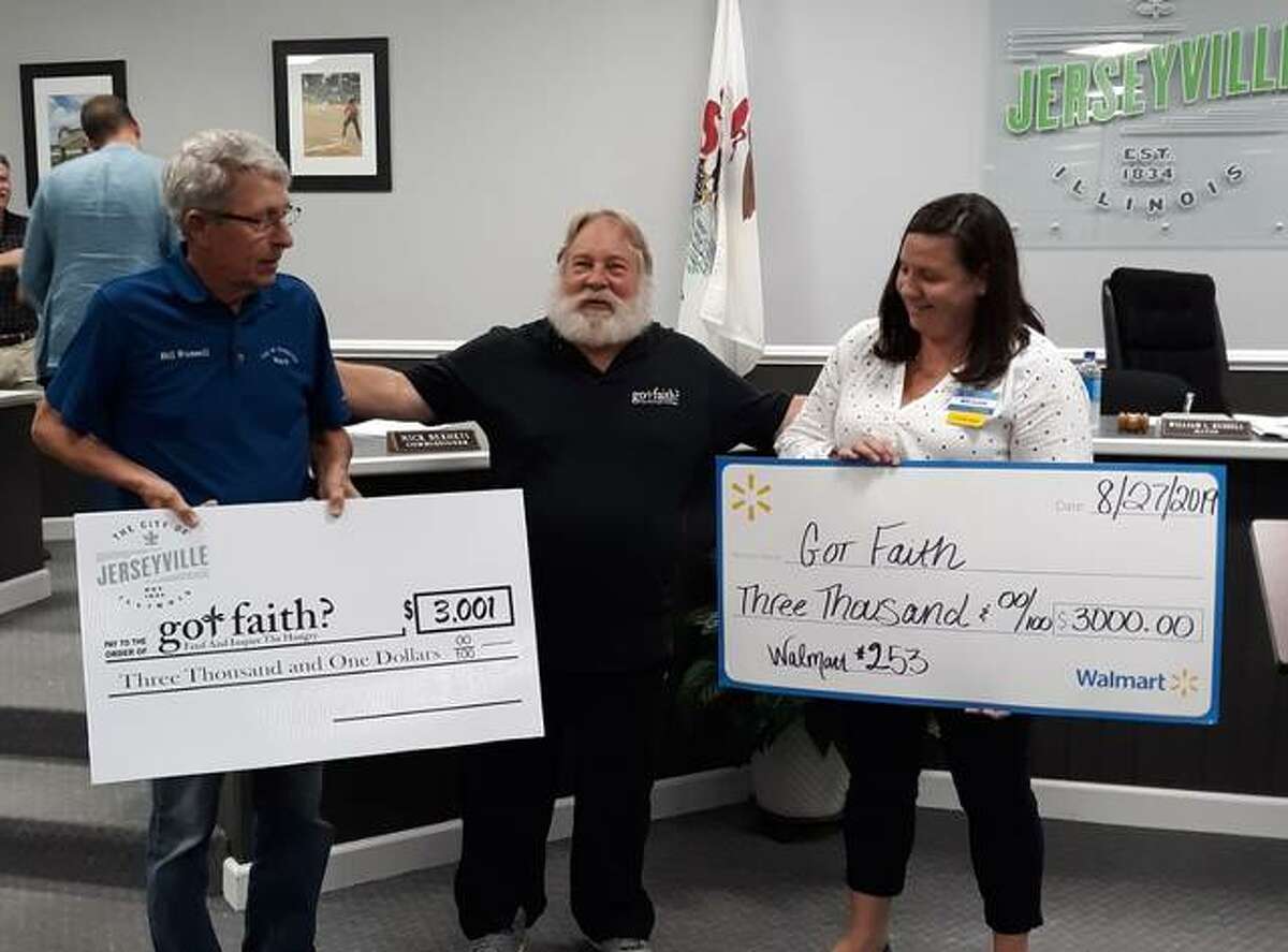 Steve Pegram, founder/president of Got Faith?, is shown with oversized checks representing gifts of $6,000. At left is Jerseyville Mayor Bill Russell; at right is Walmart Jerseyville manager Megan Labrena.